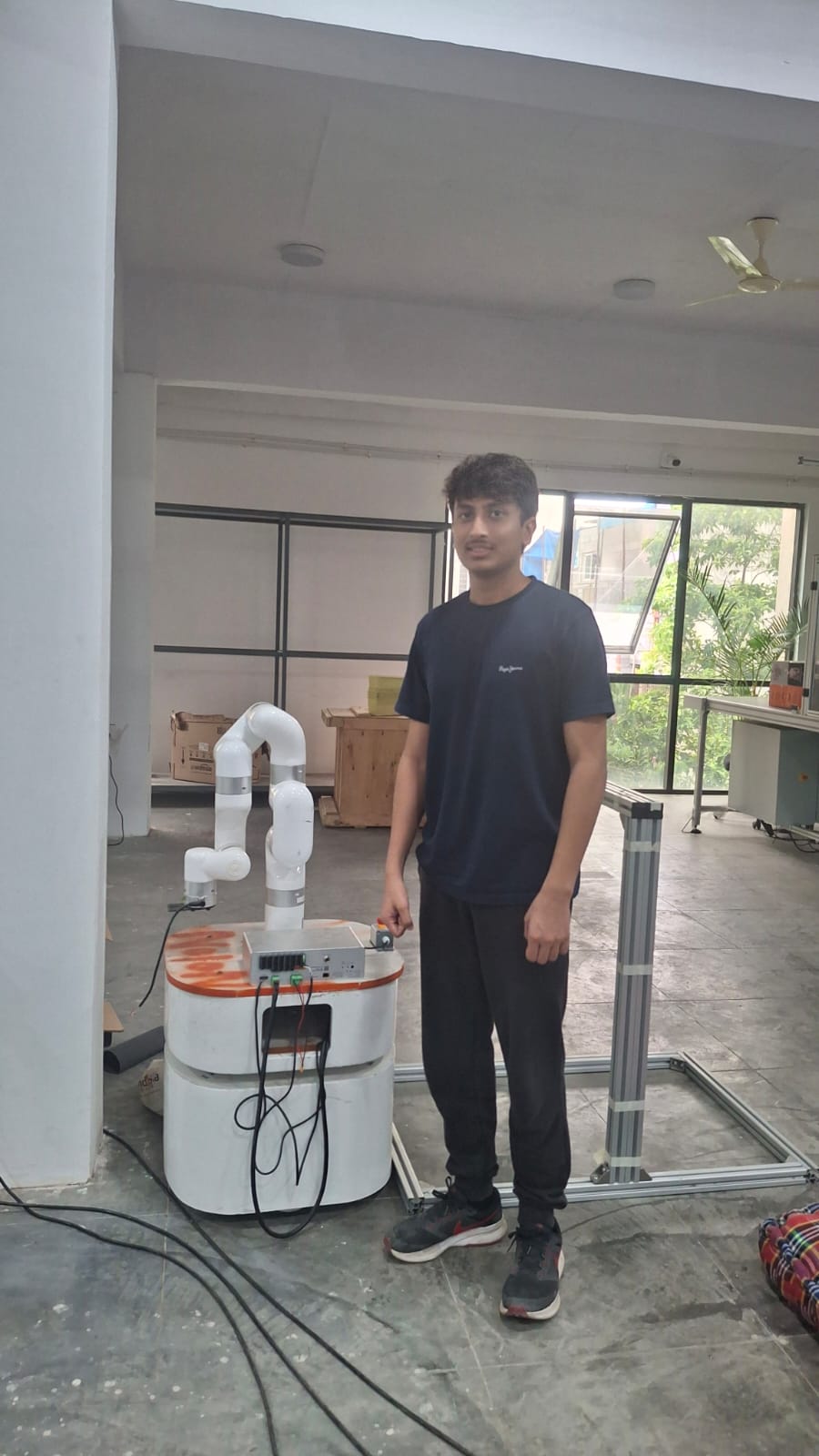 Aryaman next to the UFACTORY xArm 7 mounted on a mobile base